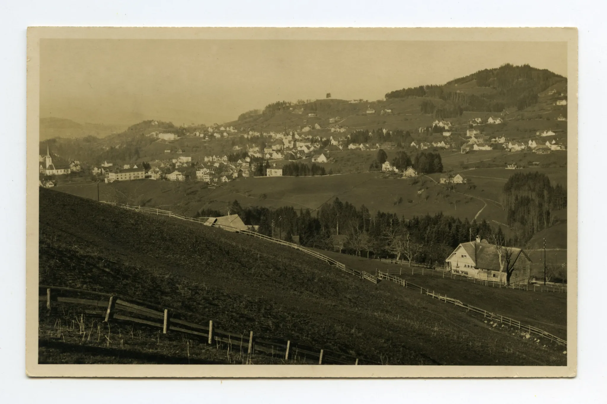 Aufnahme aus Richtung Schlatterlehn/Buechen. Beide Dorfkirchen, Zeughaus, Friedhof, Ebni, Bahnhof (halb verdeckt), Gremm/Lortanne mit Krankenhaus. Blick zu Fernblick, Schwendibüel, resp. Eggli