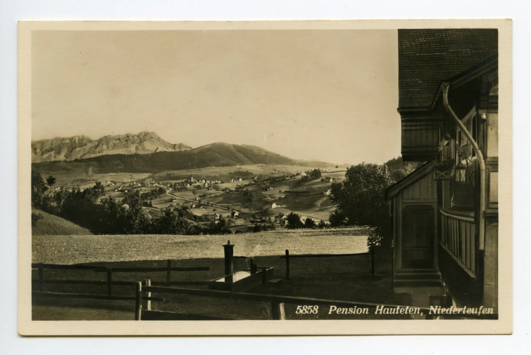 seitliche Ansicht des Eingangs mit Brunnen vor der Wirtschaft; im Hintergrund Blick auf Stein, Hundwiler Höhe und Säntis