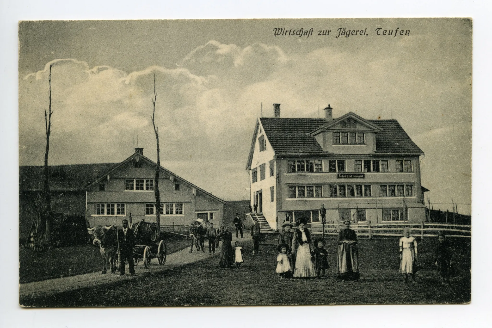 Ansicht aus Süden mit Personen vor der Wirtschaft und Ochsenfuhrwerke auf der Strasse