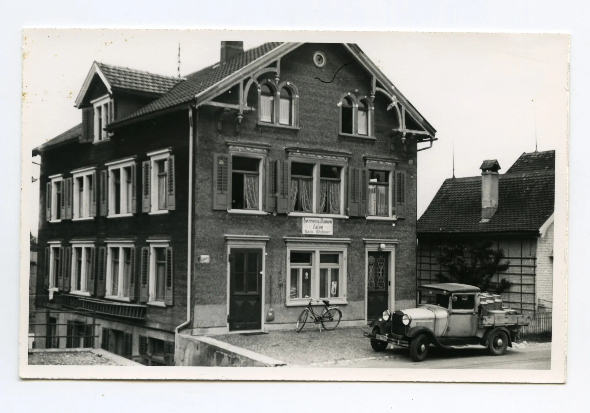 Gebäudeansicht mit Velo und Milchwagen vor dem Haus, Karten identisch