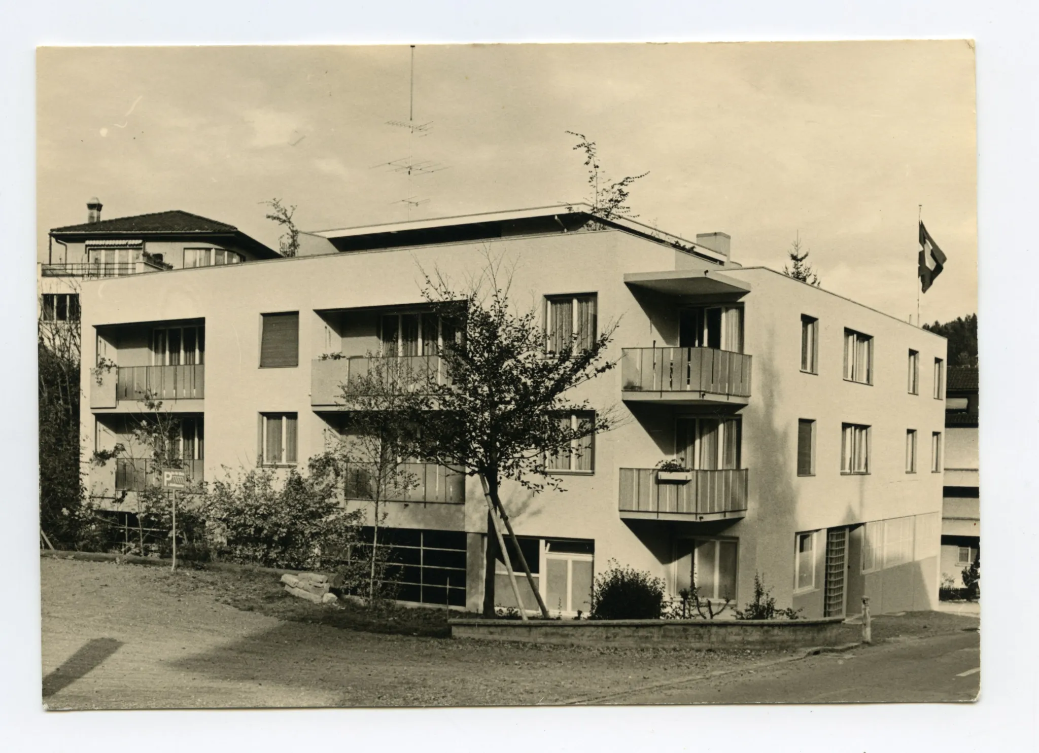 Karte 1: Firmenkomplex mit Eingangsbereich und parkenden Autos; Karte 2: Rückansicht des Firmengebäudes (Mietwohnungen mit Balkon)
