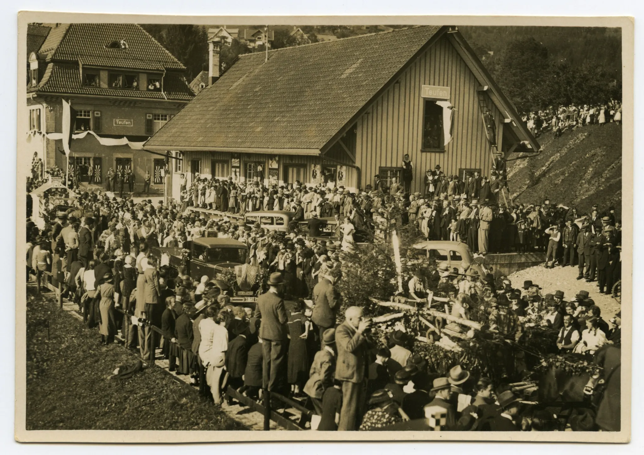 Fuhrwerk der Förster/Waldarbeiter, gefolgt von weiteren Wagen, im Hintergrund Güterschuppen und Bahnhof