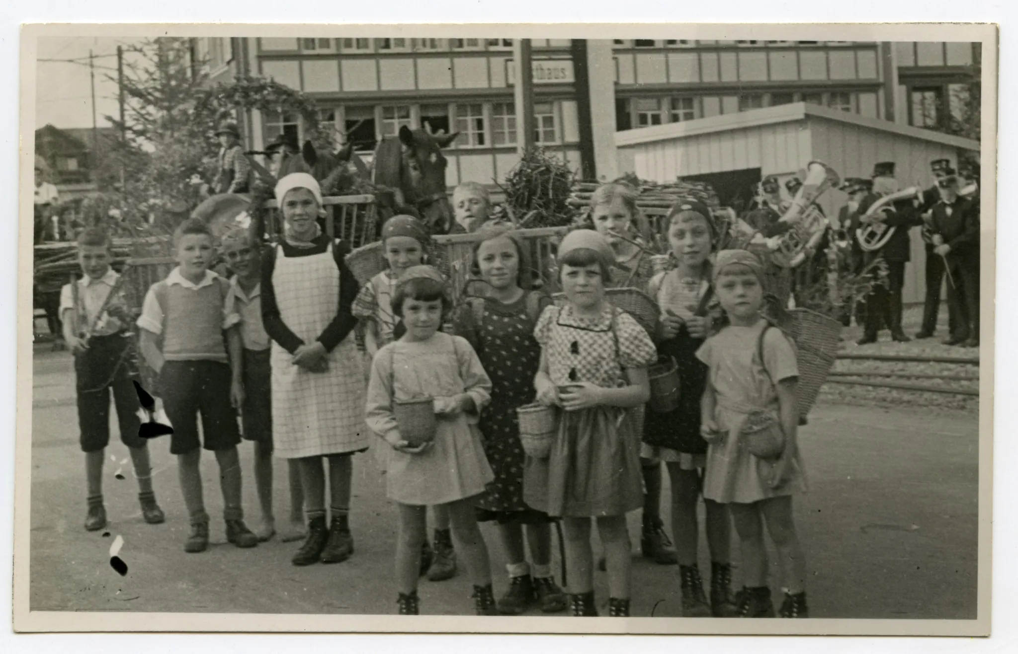 Gruppe von Kindern (Schüler) in Vorbereitung für den Umzug vor dem Restaurant Rössli Niederteufen, Kinder haben Chränzen auf dem Rücken und Beerenkörbe umgebunden