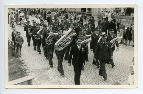 Umzug durchs Dorf auf der Strasse vor dem Güterschuppen, viele Schaulustige