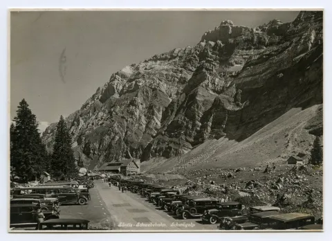 mit dem Gasthaus Schwägalp im Hintergrund und vielen parkierenden Autos rechts und links der Zufahrtstrasse